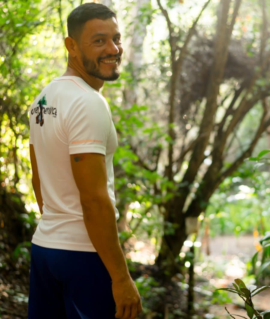 Curiel sonriendo por encima del hombro en un sendero de la selva sobre Puerto Vallarta