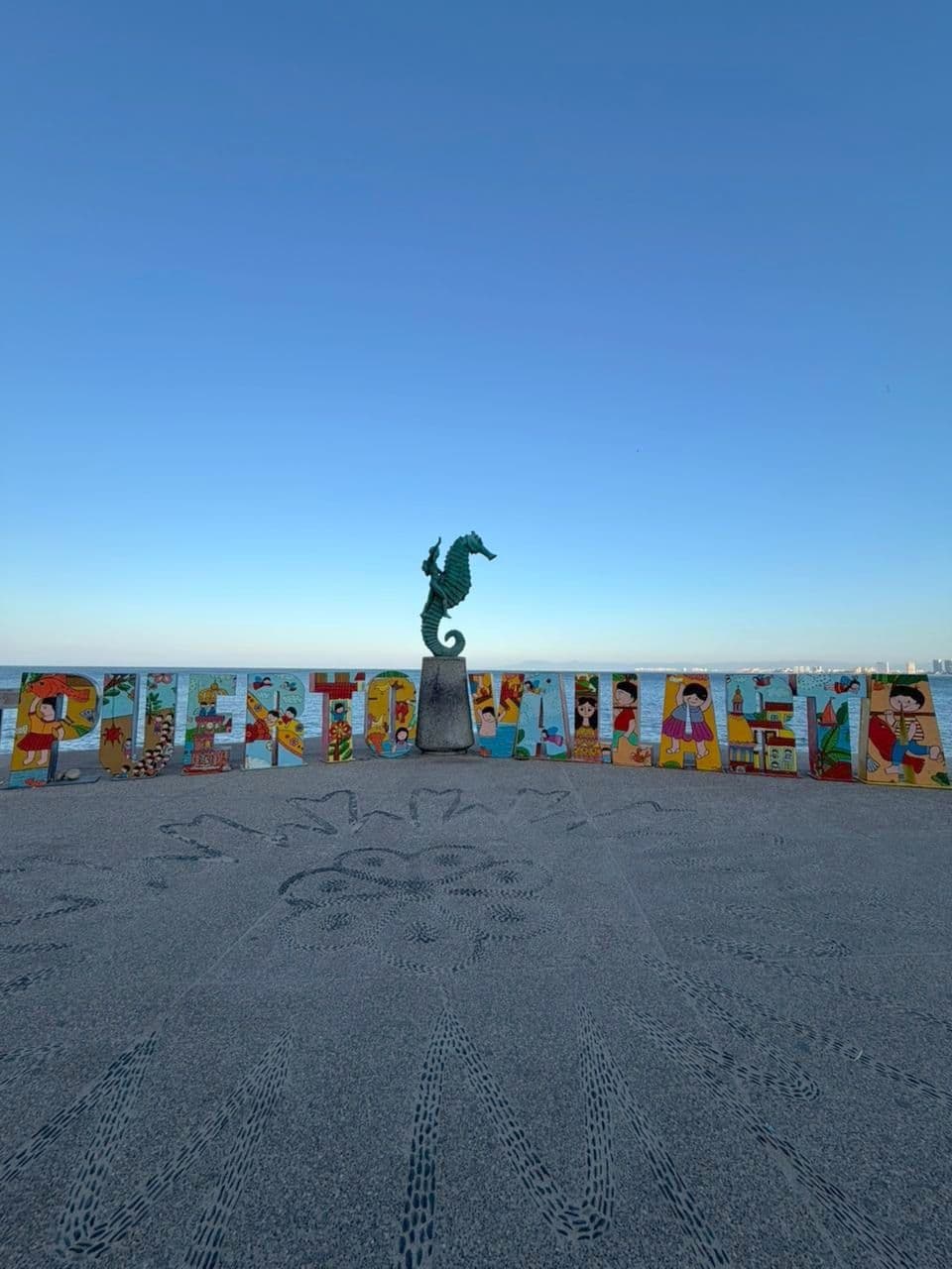 The painted Puerto Vallarta letters and the seahorse statue on the Malecón, the bay behind